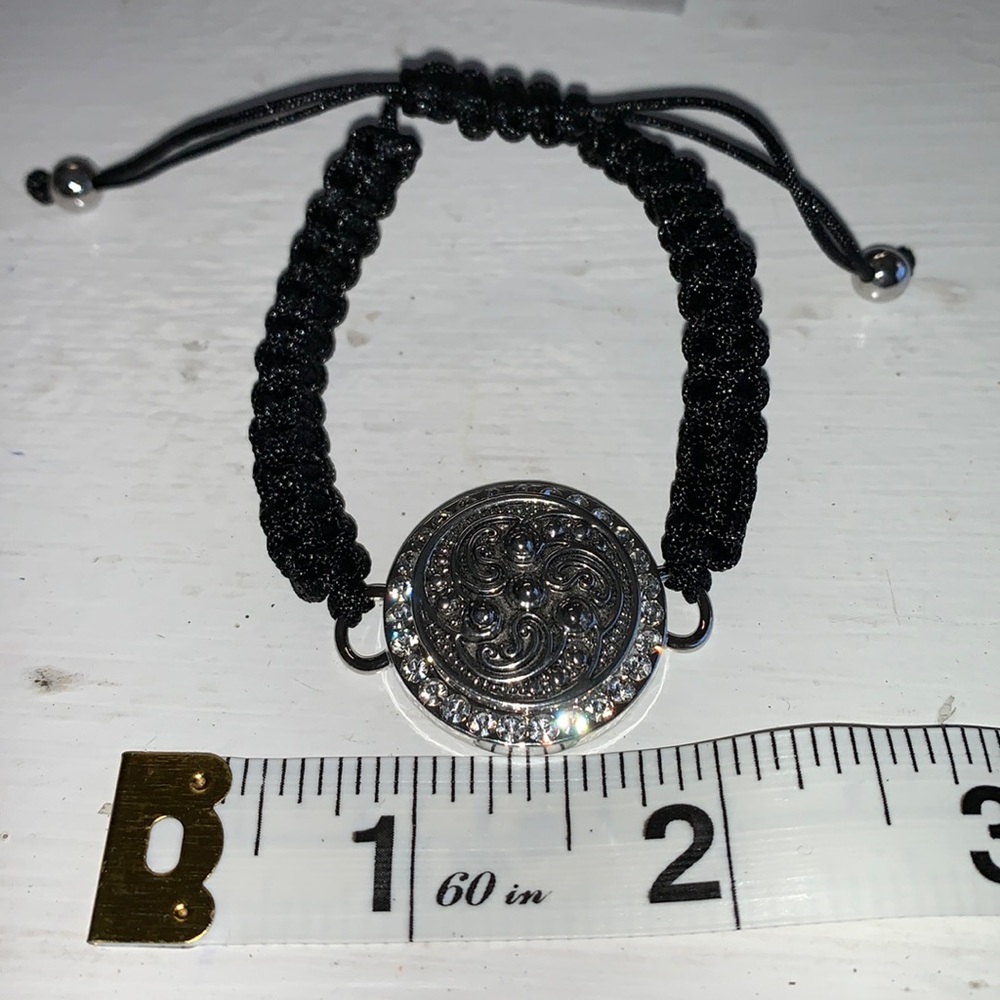 Adjustable braided black cord bracelet with one interchangeable snaps.  NWOT